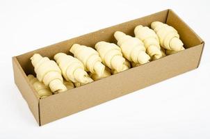 bevroren rauwe croissants in vak op witte achtergrond. studio foto