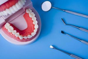 tandenmodel met tandhulpmiddelen op blauwe achtergrond foto