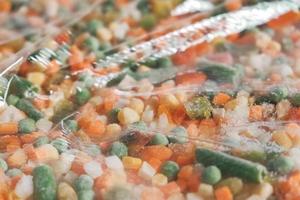 mix van diepvriesgroenten in een doorzichtige plastic verpakking. kopiëren, lege ruimte voor tekst foto