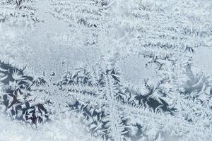 ijspatronen op bevroren glas. abstract ijspatroon op winterglas als achtergrondafbeelding foto