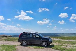 belogorsk, krim-22 mei 2018 - zwarte suv op een natuurlijke landschap-achtergrond foto