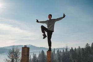 man die yoga en evenwichtsoefeningen beoefent in de winterbergen en geniet van het leven. kopiëren, lege ruimte voor tekst foto