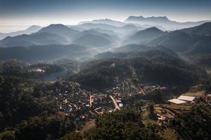 traditioneel stamdorp in de vallei met de bergtop van doi luang chiang dao en mistig in de ochtend foto