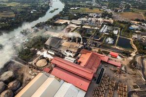 suiker bio-ethanol vertaalfabriek werkt met stoom uit de schoorsteen en suikerrietwagen foto