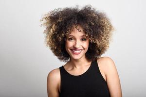 jonge zwarte vrouw met afro kapsel lachend foto