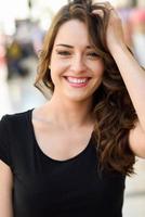 mooie jonge vrouw met blauwe ogen glimlachend in stedelijke achtergrond foto
