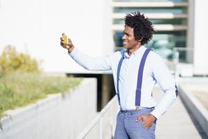 zwarte zakenman die selfie neemt met een smartphone in de stad foto