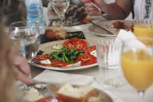 verse gezonde salade met tomaten, rucola en kaas op de restauranttafel foto