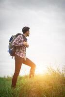 jonge hipster man buiten met rugzak op zijn schouder, tijd om te gaan reizen, avontuur met wandelen. foto