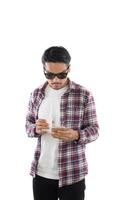 jonge hipster man kijken naar zijn smartphone terwijl SMS-berichten geïsoleerd op een witte achtergrond. foto