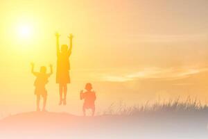 silhouet kinderen spelen gelukkige tijd bij zonsondergang foto