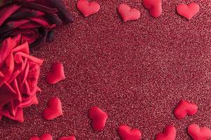 st. Valentijnsdag concept. rode scharlaken rozen en veel rode harten op rode glitter achtergrond. briefkaart banner op Valentijnsdag. liefde datum verliefde bruiloft romantiek symbool. valentijnsdag cadeau. foto