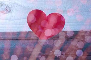 gelukkige Valentijnsdag, papieren harten op houten achtergrond met achtergrondverlichting foto