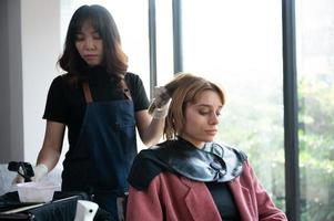 kapper en mooie klant vrouw maken behandeling haar gezondheidszorg in mode stijl salon foto