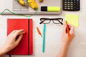 bovenaanzicht van zakelijke werkruimte met laptop en vrouwelijke handen met notebook en ruimte voor tekst. selectieve focus foto