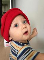 mooie babyjongen met kinderhoed poseren fotograaf voor kleurenfoto foto
