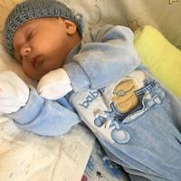 mooie slapende babyjongen met kinderhoed poseren fotograaf voor kleurenfoto foto