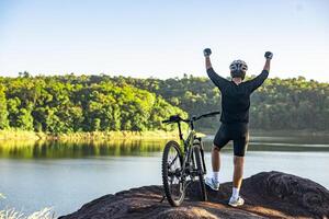 mountainbike fietser staande op de top van een berg met fiets .extreme sport concept. foto