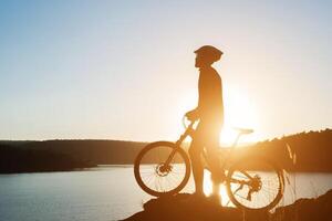 silhouet van een man op de mountainbike tijdens zonsondergang. foto