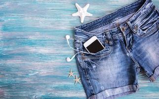 denim shorts, mobiele telefoon, koptelefoon, schelpen foto