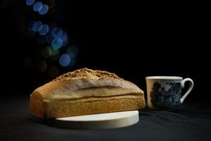 brood op een houten bord op een zwarte achtergrond foto