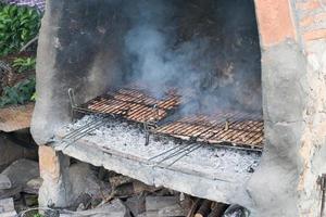 grote barbecue met twee grillroosters met lamskoteletten en varkensgeheim foto