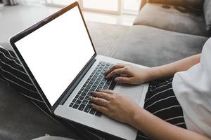 vrouw zit op de bank met laptop en kijkt naar de netflix-website. foto