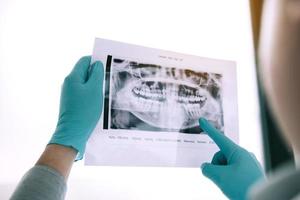 Aziatische mannelijke tandartsen analyseren röntgenfoto's van patiënten in het laboratorium. foto