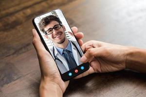 patiënt die online videogesprek voert met arts via smartphone, medische thuisconsultatie en telegezondheidsconcepten foto