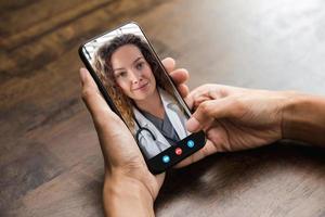 patiënt die online videogesprek voert met arts via mobiele telefoon, medische thuisconsultatie en telegezondheidsconcepten foto