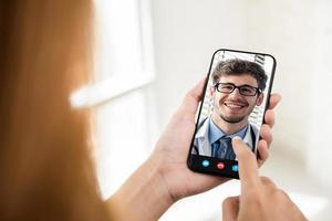 vrouwelijke patiënt die online videogesprek voert met arts via smartphone, medische thuisconsultatie en telegezondheidsconcepten foto