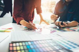 collega grafisch ontwerper die werkt met een partnerschap dat kleur kiest op het bureau in een modern kantoor. foto