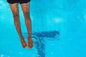 volwassen Afro-Amerikaanse man's benen onder water in zwembad foto