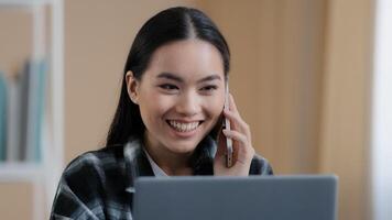 gelukkig glimlachen Aziatisch meisje Koreaans vrouw freelancer chatten met vrienden Aan telefoon beantwoorden telefoontje vriendelijk op zoek Bij laptop scherm afgelegen werken bedrijf onderhandeling maken online bestellen door smartphone foto