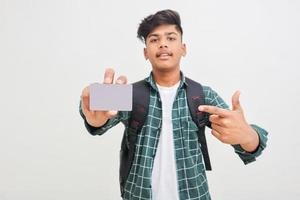 jonge indische man die debet- of creditcard op een witte achtergrond toont. foto
