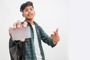 jonge indische man die debet- of creditcard op een witte achtergrond toont. foto
