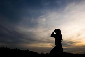 silhouet van vrouw die bidt met god foto