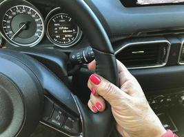 vrouwelijke hand op het stuur in de auto. foto