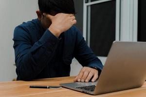 zakenman voelt zich onwel en moe terwijl hij op zijn werkplek zit in het conceptbureau voor deadlines foto