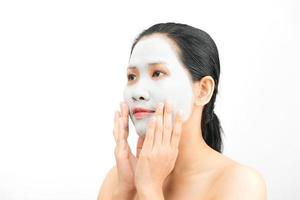 jonge vrouw klei gezichtsmasker peeling natuurlijk met zuiverend masker op haar gezicht op witte achtergrond foto
