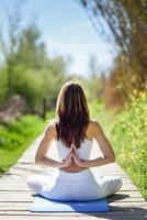 jonge mooie vrouw doet yoga in de natuur foto