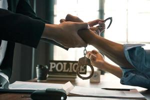 De politie arresteerde de verdachte en boeide hem om de beschuldiging van het misdrijf te erkennen. foto