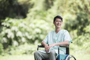 alleen jonge gehandicapte man in rolstoel in de tuin foto