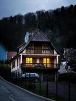 gloeiende warme huiselijke ramen in een klein Elzasser dorp. comfort en warmte in huis op een winteravond. foto