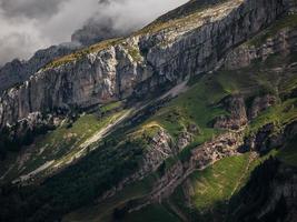 verschrikkelijke levenloze rotsen, een gletsjer in de alpen, wolken en mist verspreid over de toppen van de bergen foto