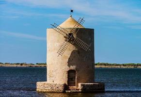 oude windmolen in italië, toscane. in het water staan foto