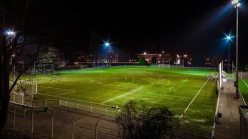 groen voetbalveld 's nachts gemarkeerd met trces mensen rennen foto