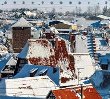 een oude Elzasser stad onder de sneeuw. de klokkentoren van de kathedraal en de daken van middeleeuwse huizen. foto