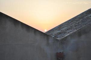 zonsondergang achter huizen foto