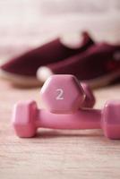 roze kleur halter, oefenmat en waterfles op witte achtergrond foto